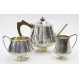 A LONDON SILVER THREE PIECE TEA SET consisting of a tea pot, cream jug and sugar bowl, dated 1913 (