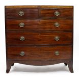 A GEORGE III BOW FRONTED MAHOGANY CHEST OF TWO SHORT AND THREE LONG DRAWERS on splaying bracket