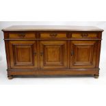 AN EARLY 20TH CENTURY SATIN WALNUT SIDE BOARD fitted with three frieze drawers over cupboard fielded