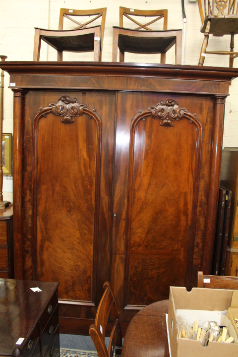 A VICTORIAN MAHOGANY WARDROBE the twin arching panelled doors set with turned pilaster columns