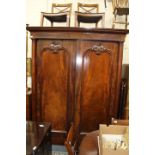 A VICTORIAN MAHOGANY WARDROBE the twin arching panelled doors set with turned pilaster columns