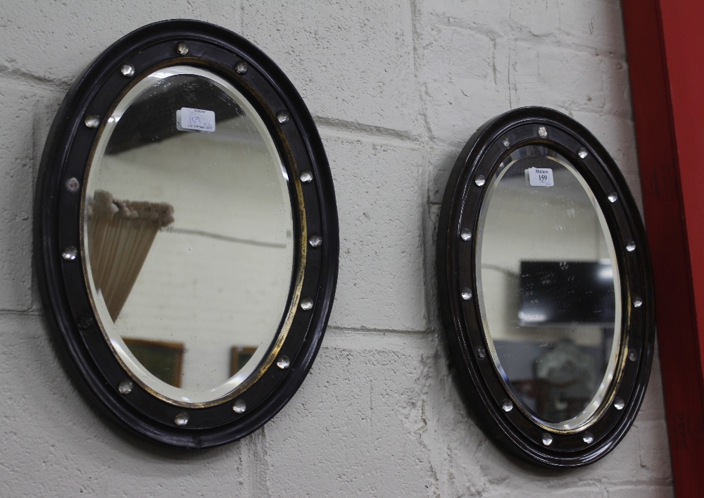A PAIR OF ANTIQUE IRISH OVAL WALL MIRRORS with scumble decorated parcel gilt frames and cut