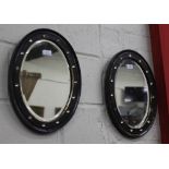A PAIR OF ANTIQUE IRISH OVAL WALL MIRRORS with scumble decorated parcel gilt frames and cut