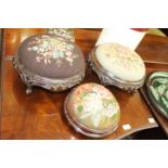 A PAIR OF VICTORIAN CARVED MAHOGANY FOOTSTOOLS with needlework seats, 29cm diameter and one other