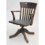 AN OAK ROTATING DESK CHAIR with leatherette inset seat