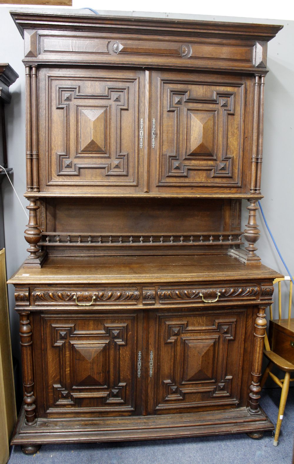 A CONTINENTAL OAK CUPBOARD with twin moulded doors above two single drawers above twin doors and
