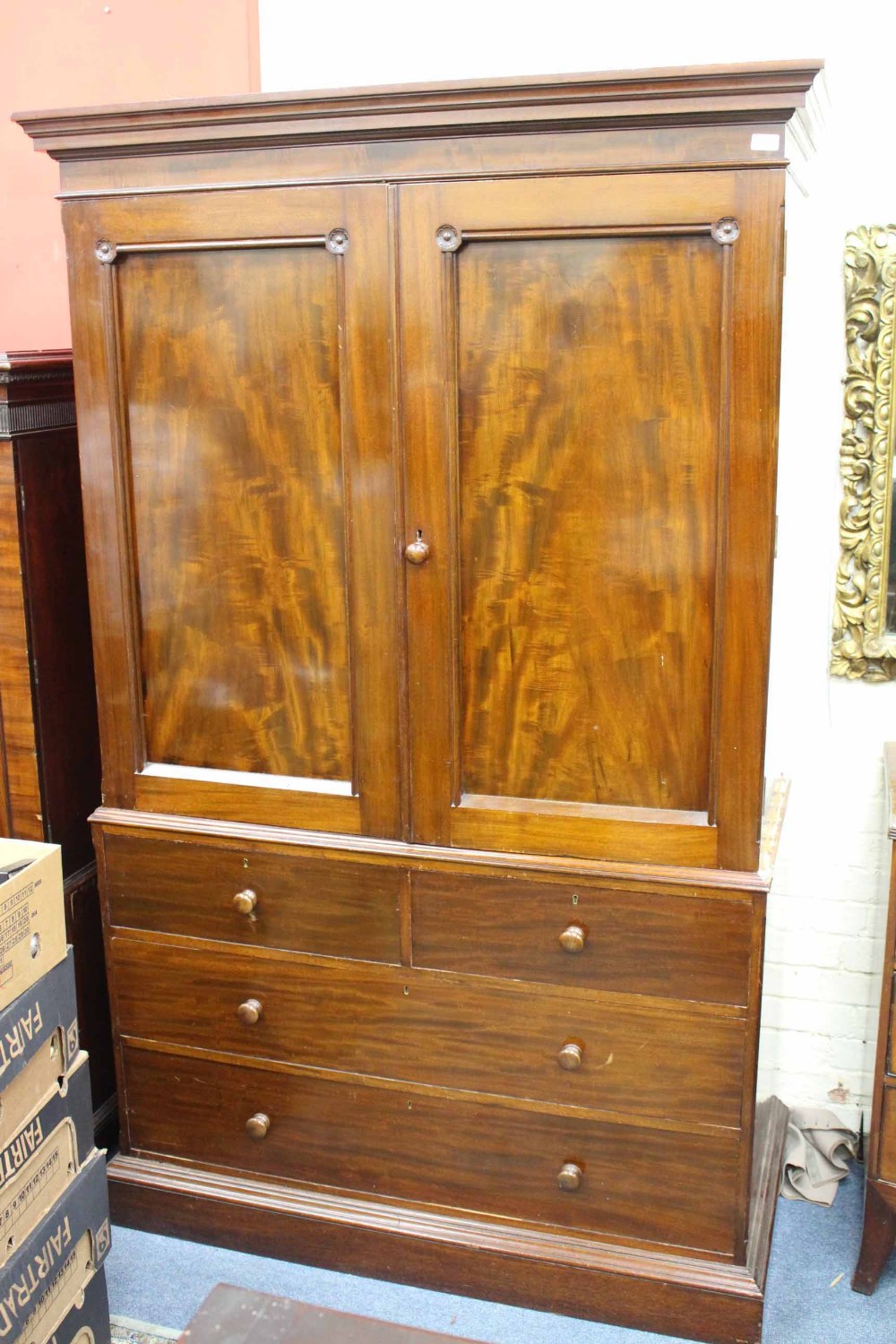 A MAHOGANY LINEN PRESS with twin panelled doors enclosing slides within over two short and three