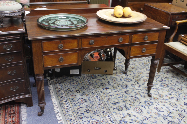 A MAHOGANY GILLOWS STYLE FIVE DRAWER WRITING TABLE with reeded tapering legs, 122cm wide x 82.5cm