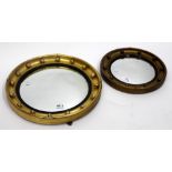 A PAIR OF REGENCY STYLE CIRCULAR CONVEX MIRRORS with decorated frames, the smallest measuring 35cm