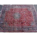 A RED GROUND MESHED RUG with a banded border and geometric decoration 300cm x 247cm