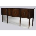 A REGENCY STYLE MAHOGANY BOW FRONTED SIDEBOARD standing on spiral twist legs with lion mask