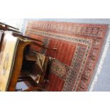 A MIDDLE EASTERN RED GROUND RUG with multiple banded border and all over geometric decoration, 170cm