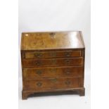 A GEORGIAN STYLE WALNUT BUREAU fitted with four drawers, standing on bracket feet, 98cm wide x 105cm