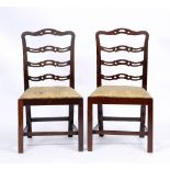 A SET OF SIX CHIPPENDALE STYLE MAHOGANY DINING CHAIRS with wavy ladder backs and drop in seats, c.