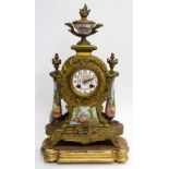 A LATE 19TH CENTURY FRENCH GILT METAL and porcelain mantle clock having an urn finial and Cherub