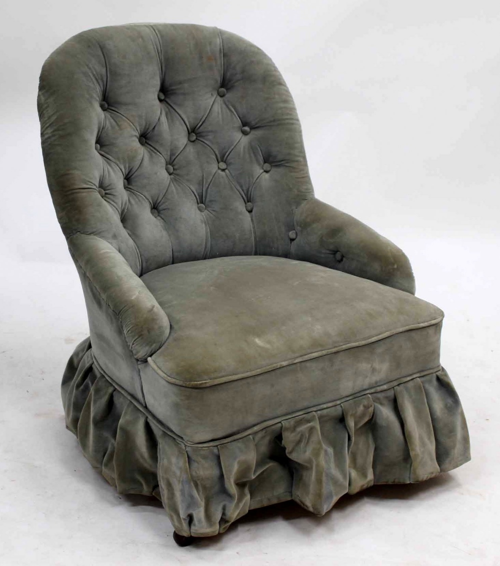 A VICTORIAN LOW OCCASIONAL CHAIR with button upholstered back and arms, turned tapering front legs