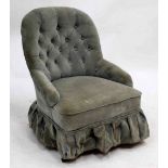 A VICTORIAN LOW OCCASIONAL CHAIR with button upholstered back and arms, turned tapering front legs