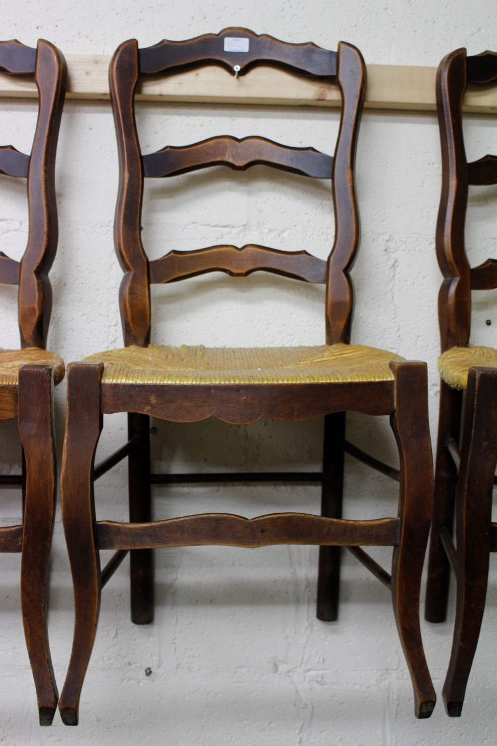 A SET OF SIX FRENCH LADDER BACK KITCHEN CHAIRS with rush seats (6)