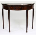 A GEORGE III MAHOGANY DEMI-LUNE FOLD OVER CARD TABLE standing on square tapering legs, terminating