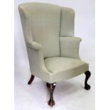 A GEORGE III STYLE WING BACK UPHOLSTERED ARMCHAIR with cabriole legs and claw and ball feet