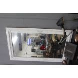 A RECTANGULAR WALL MIRROR with bevelled glass, 83cm x 150cm