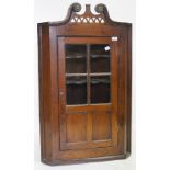 AN ANTIQUE OAK HANGING CORNER CABINET with glazed panelled door, 105cm high