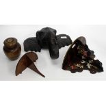 A WOOD CARVING IN THE FORM OF A ELEPHANTS HEAD, 32cm wide together with a treen tea caddy and two