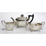 A THREE PIECE SHEFFIELD SILVER TEASET consisting of a teapot, sucrier and cream jug standing on four