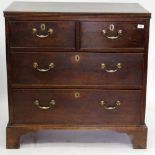 A GEORGE III OAK CHEST OF TWO SHORT AND TWO LONG DRAWERS having brass swan neck handles, and