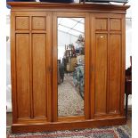 AN EARLY 20TH CENTURY MAHOGANY TRIPLE WARDROBE with central mirrored door and gilded decoration,