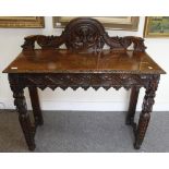 A 19TH CENTURY CARVED OAK SIDE TABLE with a raised back, 105cm wide x 103cm high