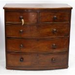 A 19TH CENTURY MAHOGANY BOW FRONTED CHEST of two short and three long drawers with turned knobs