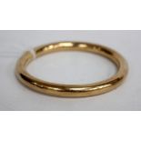 A YELLOW METAL BANGLE marked with 15ct and with inscription to the inside 8cm across