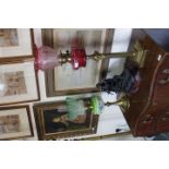 TWO VICTORIAN BRASS OIL LAMPS one with a Corinthian column support to the cranberry glass oil