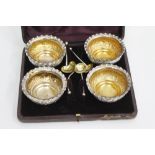 A BOXED SET of four Birmingham Victorian salts with gilt lined interiors and engraved foliate