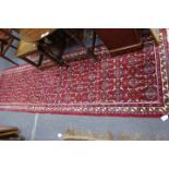 A LATE 20TH CENTURY RED GROUND RUNNER with a banded border 80cm x 295cm together with three old