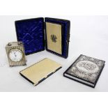 A CHESTER SILVER TIMEPIECE with engine turned decoration and three card cases / notebooks, one