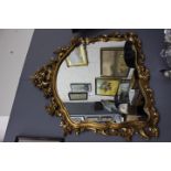 A MODERN GILT FRAMED MIRROR with scrolling floral designs 120cm x 115cm