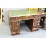 A VICTORIAN OAK PEDESTAL DESK with a green leather inset top and turned knob handles, the top 89cm x