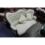 AN ANTIQUE MAHOGANY FRAMED HIGH BACK SETTEE with green button upholstered back and seat, carved