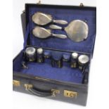 A TRAVELLING CASE initialled T. D. with fitted interior containing silver mounted brushes,