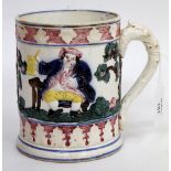 A LATE 19TH / EARLY 20TH CENTURY POTTERY TANKARD with relief figure in tree decoration, 15cm high