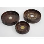 TWO WOODEN TREEN BOTTLE COASTERS with circular silver inserts and one other (3)