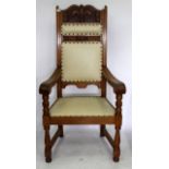 AN OAK OPEN ARMCHAIR of large proportions with carved decoration to the back, scroll arms and turned