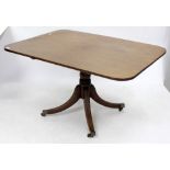 A MAHOGANY RECTANGULAR TILT TOP BREAKFAST TABLE with four reeded legs, terminated in brass feet