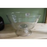 AN ANTIQUE CIRCULAR GLASS BOWL on a spreading circular foot with folded edge and with pontil mark