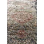 A LARGE MACHINE MADE ORIENTAL STYLE RUG the central green ground field decorated with animals and