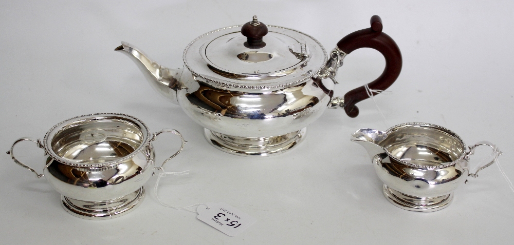 A MAPLE & CO LONDON SILVER TEA SET consisting of a tea pot, cream jug and sucrier with twin