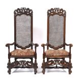 A PAIR OF EDWARDIAN CAROLEAN STYLE HIGH BACKED DINING CHAIRS with caned backs and seats, scrolling