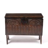 A SMALL LATE 17TH / EARLY 18TH CENTURY SIX PLANK COFFER with carved top and sides, standing on cut
